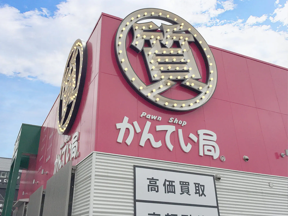 質屋かんてい局仙台泉店は、店舗前にゆったり使える広い駐車場を備えており、お車でのご来店が非常に便利な点が大きな特徴です。複数台が楽に停められるスペースがあり、混み合う時間帯でも安心してご利用いただけます。道路からも入りやすい設計になっているため、初めての方でもスムーズに駐車していただけます。大きな看板と明るい外観が目印になっており、遠くからでも店の位置がわかりやすいのも魅力です。ガラス張りで明るい店構えは、外から店内が見えやすく安心感があり、初めてのご来店でも入りやすい雰囲気を意識しています。買い物や査定での滞在時間が長くなっても、時間を気にせず駐車できる環境を整えているため、ゆっくり店内をご覧いただけます。夜間でも駐車場と看板はしっかり照明が入り、安全にお越しいただけます。地域の皆さまに気軽に立ち寄っていただける店舗を目指し、駐車のしやすさと利用しやすさを大切にした外観づくりを行っています。お車でお越しの際もどうぞ安心してご利用ください。